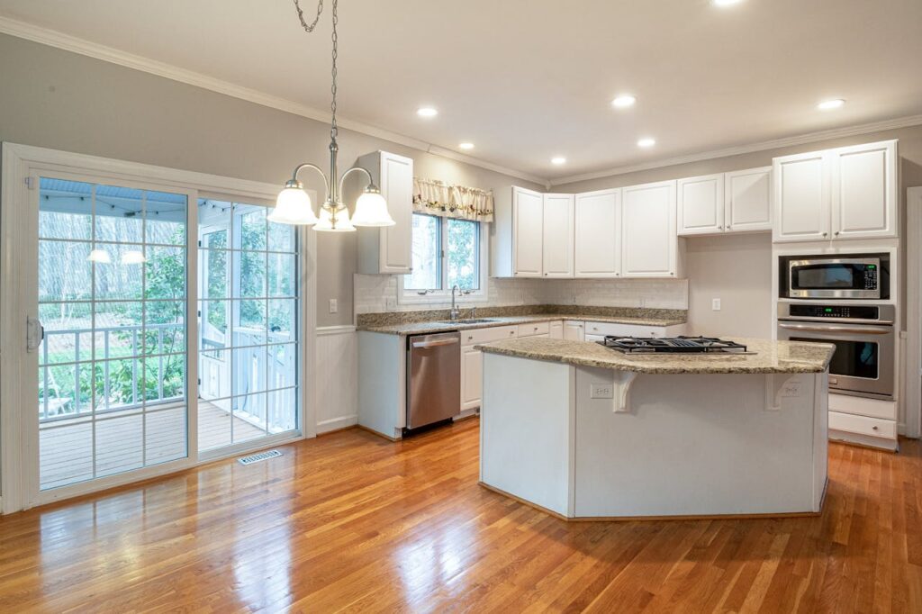 pexels-photo-3935350 Bright modern kitchen featuring marble island and wooden flooring, ideal for family spaces.